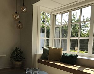 Zonnige zithoek met kussens in Charmeverblijf Juliette, vakantiehuis in Kasterlee, Antwerpen.