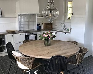 Gezellige eetkamer met houten tafel in Charmeverblijf Juliette, vakantiehuis in Kasterlee, Antwerpen.