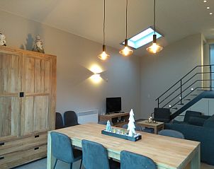 Gezellige woonkamer in De Drieshoeve, vakantiehuis in Kasterlee, Antwerpen met houten meubels.