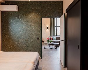 Slaapkamer in de Schuur van Driehoekshoeve, Kasterlee, met comfortabele bedden en rustgevende inrichting.