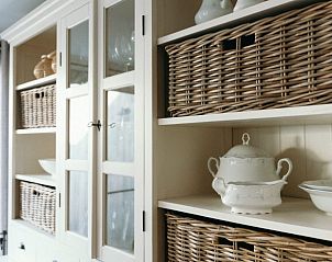 Elegante servieskast in Maison Patisson, vakantiehuis in Kasterlee, met rieten manden en porselein, Antwerpen, Belgi.