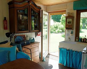 Gezellige binnenruimte van Vakantiehuis in Goulles, Limousin, met uitzicht op de groene tuin.