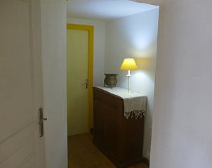 Gezellige binnenruimte in Vakantiehuisje in Bujaleuf, Frankrijk, met sfeervolle lamp en houten kast.