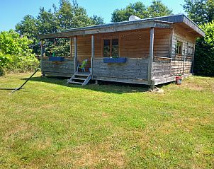 Self-contained, luxury eco-chalet in Eymoutiers, Limousin, featuring an inviting porch and lush surroundings.
