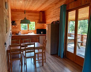 Discover the cozy interior of this self-contained, luxury eco-chalet in Eymoutiers, Limousin, featuring wood paneling and views of the natural surroundings.