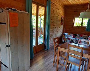 Cozy interior of the self-contained, luxury eco-chalet in Eymoutiers, Limousin, France, featuring wood paneling and a view of the terrace.