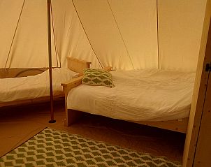 Cozy bedroom in the Bell Tent 6M, a glamping lodge in Eymoutiers, Limousin, France.