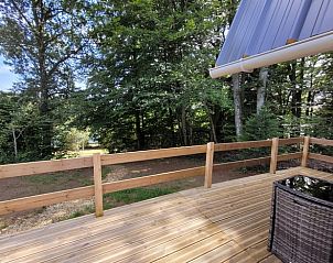 Genieen Sie die Holzterrasse des Ferienhauses in Neuvic, umgeben von den ruhigen Wldern des Limousin, Frankreich.