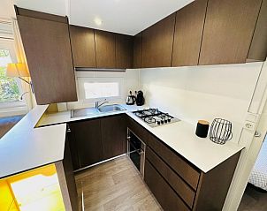 Moderne keuken in Chalet Toppy nr 5 in Argels-sur-Mer, Languedoc/Roussillon, met strakke houten kasten en veel lichtinval.