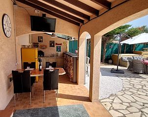 Ontspan op het charmante terras van VILLA ZAPPA, een vakantiehuis in Tuchan, Languedoc, met een uitnodigende buitenkeuken en zithoek.