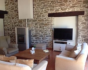 Gezellige woonkamer in vakantiehuis Coup de Coeur, Marseillette, Languedoc, met stenen muren en comfortabele zitplaatsen.