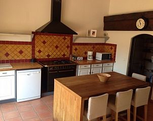 Gezellige keuken in vakantiehuis Coup de coeur, Marseillette, Languedoc, met rustieke houten tafel en moderne apparatuur.