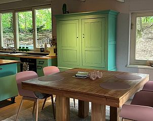Cozy indoor area of Holiday Home in Arendonk, Antwerp, Belgium, with wooden table and view of green surroundings.