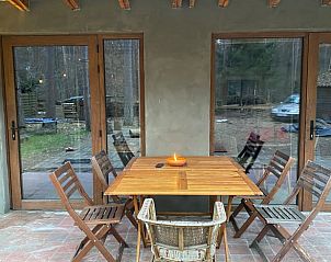 Vakantiehuisje in Wechelderzande, Lille met een uitnodigende veranda en houten eettafel in de bosrijke omgeving van Antwerpen.