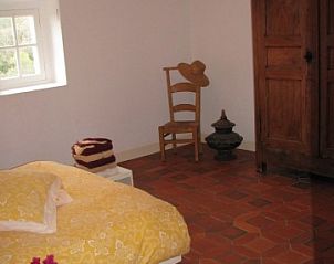 Gezellige slaapkamer in vakantiehuis KLEIN KLOOSTERTJE, Nimes, Languedoc, met rustiek interieur en warme sfeer.