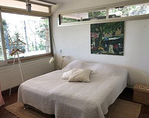 Sfeervolle slaapkamer in Villa Les Darrots, Trans-en-Provence, met kunst aan de muur en een rustgevend uitzicht op de natuur.