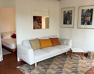 Gemtliches Wohnzimmer in einer charmanten Wohnung in Villecroze, Provence, mit bequemem Sofa und Kunstwerken an den Wnden.