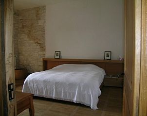 Slaapkamer in Chteau d' Aix, een charmant vakantiehuis in Lot Saux, Midi-Pyrenees, Frankrijk, met rustieke stenen muren.
