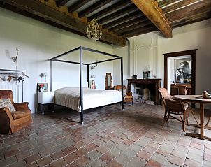 Chteau d' Aix in Lot Saux, Frankrijk, biedt een ruime slaapkamer met rustieke charme en authentieke details in een vakantiehuis.