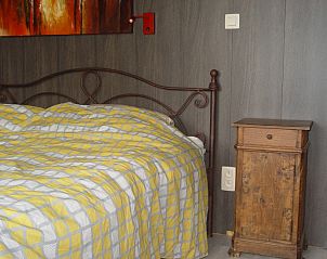 Gezellige slaapkamer in vakantiehuis l'auloue, Barran, Midi-Pyrnes, met een rustieke uitstraling en comfortabel bed.