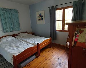 Cozy bedroom in Gte du Lion, vacation home in Figeac, Midi-Pyrenees, France with rustic wooden furniture.