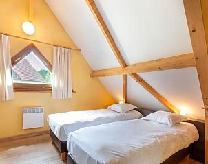 Gemtliches Esszimmer im Ferienhaus Lac Bleu No 14, Lacapelle-Marival, Midi-Pyrenen, Frankreich, mit Holzdecke und moderner Einrichtung.