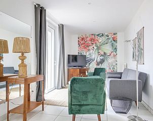 Stijlvolle woonkamer in Vakantiehuisje in Peyrole, Midi/Pyrenees, met kleurrijke muurschildering en comfortabele zitruimte.