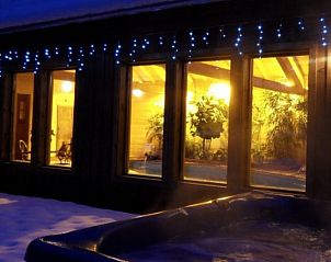 Geniet van de winterse sfeer bij Chalet Andu in Avoriaz, Frankrijk, met een verlichte veranda en uitnodigende binnenruimte.