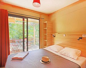 Gezellige slaapkamer in Chalet Ottawa, Dardilly, met uitzicht op het groene terras in de Rhone-Alpes, Frankrijk.