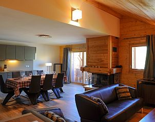 Gezellige woonkamer in Chalet Adele, Saint Martin de Belleville, Frankrijk, met open haard en eetruimte.