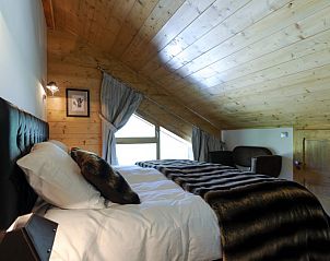 Gezellige slaapkamer in Chalet Adele, Saint Martin de Belleville, Rhone-Alphes, met houten interieur en luxe beddengoed.