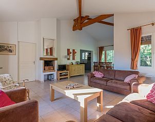 Gezellige woonkamer in Domaine Les Rives de lArdche, Vallon-Pont-d'Arc, vakantiehuis met houten meubels en open haard.