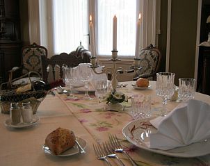 Geniet van een elegant gedekte eettafel in Chateau de Moulin le Comte, een charmante bed and breakfast in Aire-sur-la-Lys, Frankrijk.