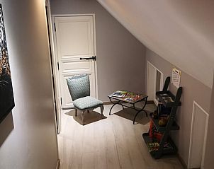 Ontspannen leeshoek in Vakantiehuisje in GOMMEGNIES, Nord / Pas de Calais, Frankrijk, met comfortabele stoel en tijdschriften.