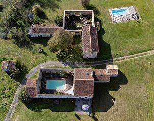 Luchtfoto van Les Escures 2, een vakantiehuis in Champagne-et-Fontaine, Aquitaine, met twee zwembaden en groene omgeving.