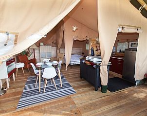 Gezellige binnenruimte van Vakantiehuis in Celles, Aquitaine, Frankrijk met eethoek en keuken in een glamping lodge.