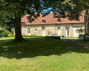Vakantiehuis in St. Sulpice d'Excideuil met rustieke stenen gevel, omgeven door groene natuur in Aquitaine, Frankrijk.