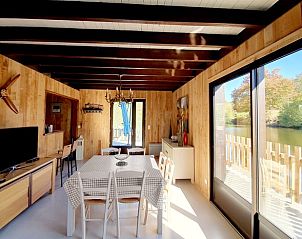 Gezellige woonkamer van Huisje in Saint-Estphe, vakantiehuis in Aquitaine, Frankrijk, met warme houten inrichting en open haard.