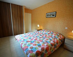 Cozy bedroom in La Laureraie, vacation home in Terrasson-Lavilledieu, Aquitaine with colorful bedding and warm atmosphere.