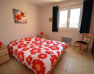 Cozy bedroom in vacation home La Laureraie, Terrasson-Lavilledieu, Aquitaine, with colorful interior and window with a view.