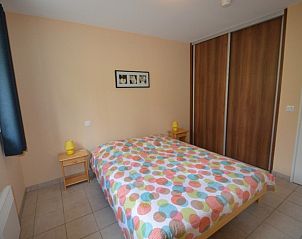 Cozy bedroom in La Lavanderaie, vacation home in Terrasson-Lavilledieu, Aquitaine, France, with colorful bedding.