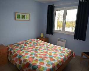 Cozy bedroom in vacation home La Lavanderaie, Terrasson-Lavilledieu, Aquitaine, with colorful interior and views of nature.