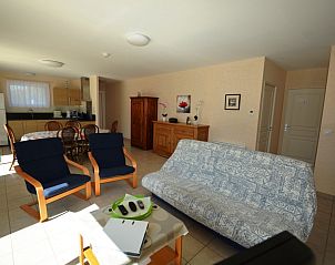 Spacious living room of vacation home La Roseraie in Terrasson-Lavilledieu, Aquitaine, with comfortable sitting area and dining area.