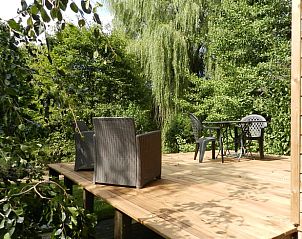 Genieen Sie die Terrasse des Ferienhauses in Esquhries, Picardie, Frankreich, umgeben von ppiger Natur fr einen entspannten Urlaub.