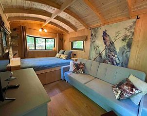 Slaapkamer in Pipowagen de Pauw nabij Maastricht in Lanaken, Limburg, Belgi, met comfortabel bed en sfeervolle decoratie.