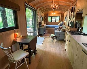 Open leefruimte in Pipowagen de Pauw nabij Maastricht in Lanaken, Limburg, Belgi, met keuken en zithoek voor ontspanning.