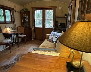 Sfeervolle zithoek in Pipowagen de Zwaan, Lanaken, Belgi, met uitzicht op de groene omgeving van Hoge Kempen.