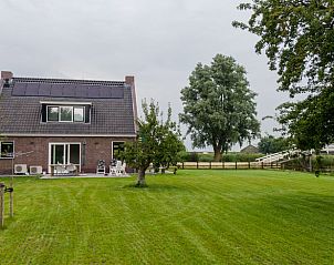 Hinterhof des Ferienhauses in Molkwerum mit groem Rasen und Zugang zur friesischen Natur.
