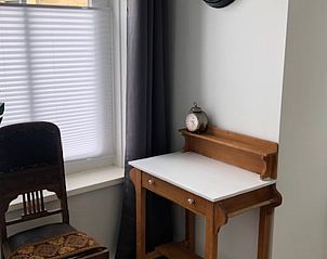 Gemtliche Ecke im Ferienhaus in Molkwerum mit antikem Schreibtisch und dekorativem Stuhl.