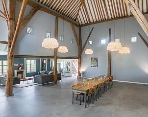 Grote eetzaal in Vakantiehuisje in Piaam met lange houten tafels, perfect voor groepsdiners aan de Friese meren.